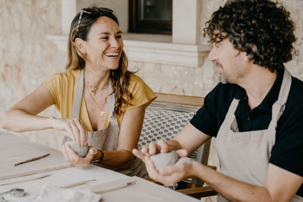 Two people working with clay at a table