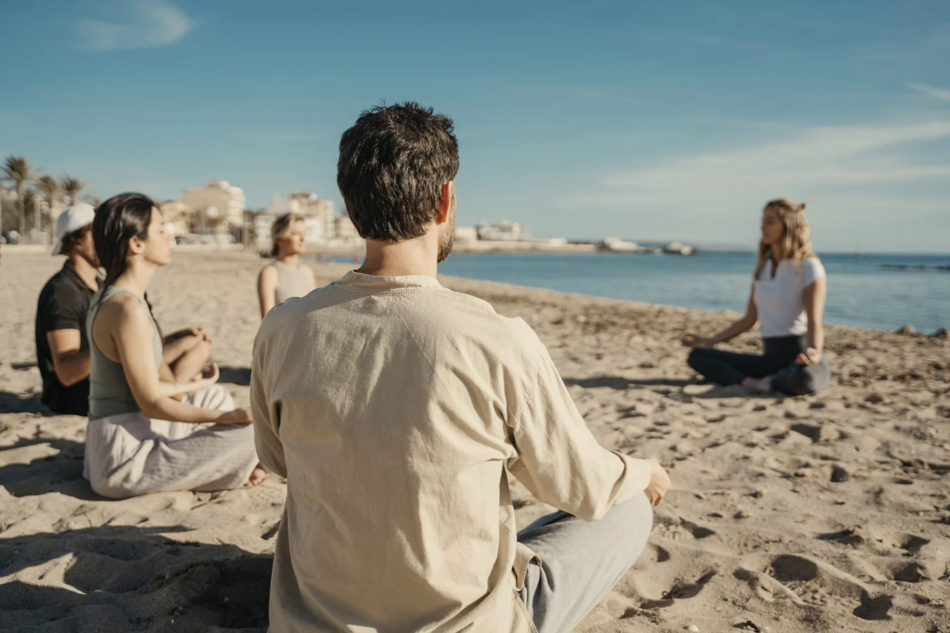 Des personnes assises en tailleur sur une plage